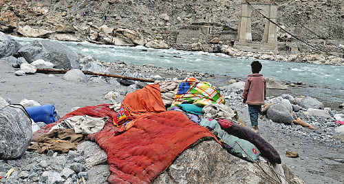Baziga’s son next to the Gilgit River after the ruin of his home.